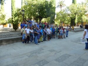 Unas 30 personas con diversidad funcional cognitiva escuchan la información sobre la Mezquita-Catedral y el Patio de los Naranjos.